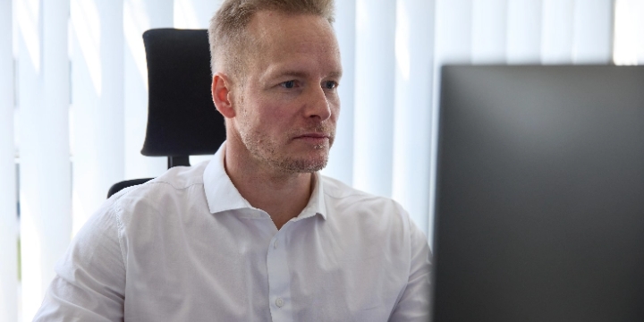 Rechtsanwalt Maximilian Adelung arbeitet konzentriert am Computer im Büro