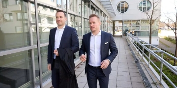 Die Rechtsanwälte Florian Friese und Maximilian Adelung gehen gemeinsam vor dem Kanzleigebäude